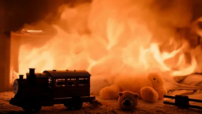Toy Train And Teddy Bear In Burning Bedroom