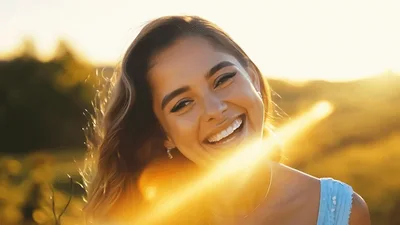 Happy Young Woman Laughing Outdoors In Golden Hour Sunlight