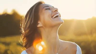 Happy Woman Laughing Outdoors During Golden Hour