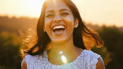 Happy Young Woman Laughing Outdoors During Golden Hour