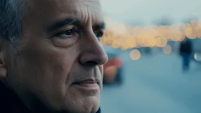 Thoughtful Elderly Man Standing On A Busy City Street