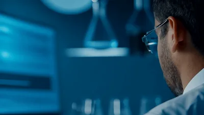 Scientist Analyzing Data On Computer In Laboratory