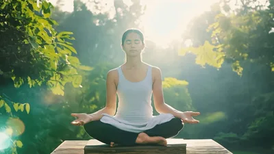 Young Woman Meditating In Lotus Position Outdoors
