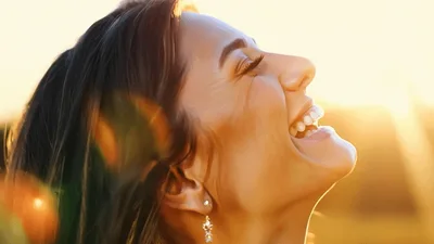Happy Woman Laughing Outdoors During Golden Hour