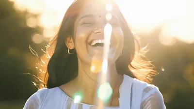 Young Indian Woman Laughing Outdoors In Golden Hour Sunlight