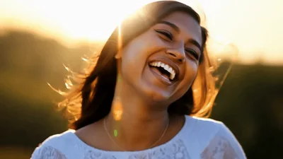 Young Indian Woman Laughing Outdoors During Golden Hour