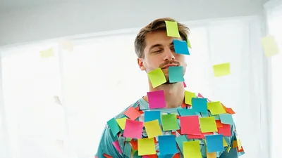 Man Covered In Sticky Notes Standing In Bright Room