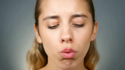 Young Woman Blowing Air From Her Mouth