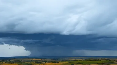 Supercell Storm Cloud With Lightning Strike Over Landscape