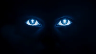 Glowing Human Eyes Emerging From Darkness In Blue Light