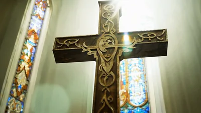 Ornate Wooden Cross Standing Inside A Church