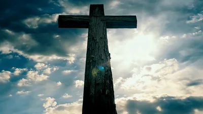Wooden Cross Silhouette Against Dramatic Cloudy Sky