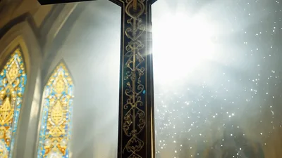 Ornate Wooden Crucifix Standing In A Sunlit Church