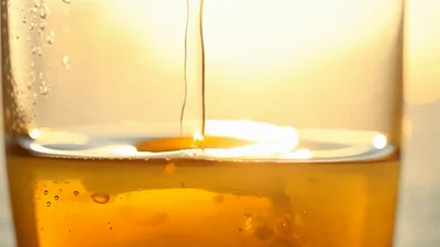 Golden Beer Pouring Into A Glass At Sunset