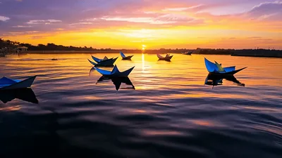 Paper Boats Floating On A Calm River At Sunset