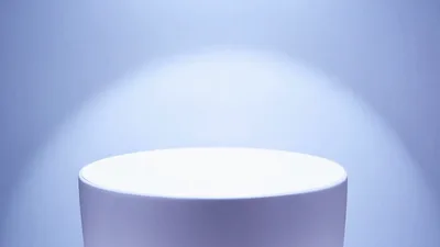 Empty White Circular Pedestal Rotating Against Blue Background