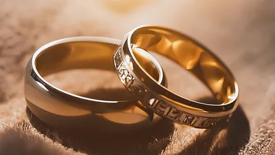 Two Golden Wedding Rings Resting On Soft Fabric