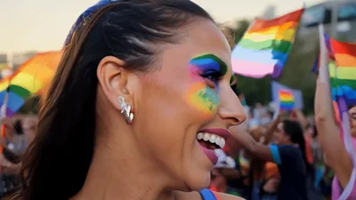 Woman With Rainbow Face Paint Celebrating At Pride Parade