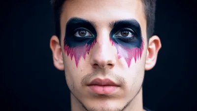 Young Man With Artistic Dark Eye Makeup Looking Forward
