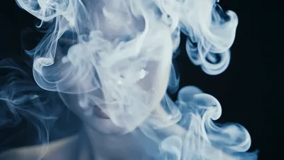 Young Woman Emerging From Thick White Smoke