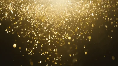 Golden Glitter Particles Falling Downwards Against Dark Background