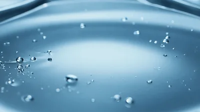 Water Stream Pouring Into A Calm Liquid Surface