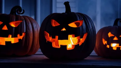 Three Glowing Jack O Lanterns On A Porch