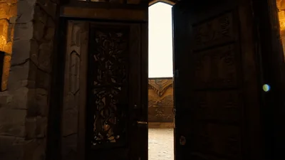 Ornate Wooden Door Opening To A Bright Courtyard