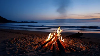 Bonfire Burning On A Sandy Beach At Twilight
