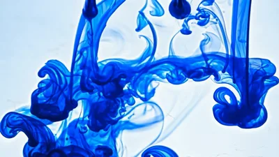 Blue Ink Droplets Dissolving In Clear Water