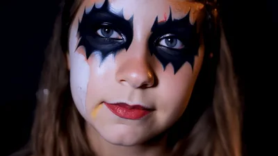 Young Girl Applying Halloween Makeup To Her Eyes