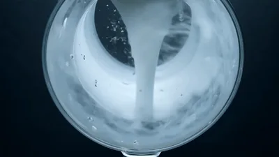 White Liquid Swirling Inside A Glass Container