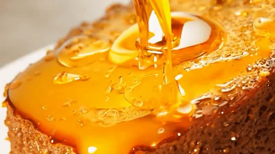 Golden Honey Pouring Over Toasted Bread Slice
