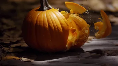 Pumpkin Exploding Into Pieces On Wooden Surface