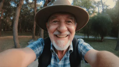 Senior Man Riding Bicycle Through Park