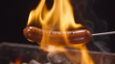 Sausage Grilling Over Open Flames On A Skewer