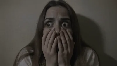 Terrified Young Woman Hiding In Dark Room