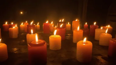 Many Burning Candles Glowing In The Dark