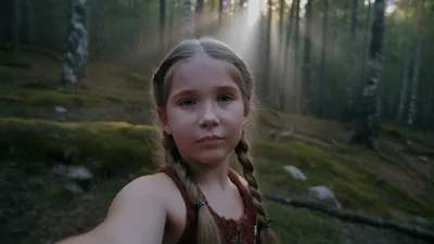 Young Girl Filming Herself In A Sunlit Forest