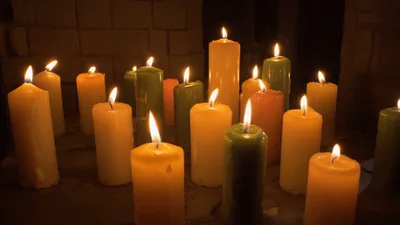 Multiple Colorful Candles Burning In A Dark Room