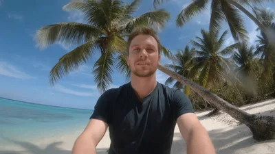 Young Man Recording Selfie Video On Tropical Beach