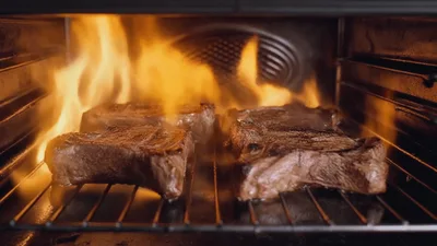 Steaks Grilling Over Open Flames In Oven