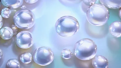Iridescent Spheres Floating Over A Shimmering Surface
