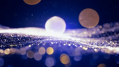 Glowing Particle Sphere Rising Above Abstract Glittering Waves