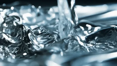Clear Water Pouring Onto A Reflective Metallic Surface