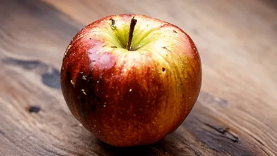 Fresh Red Apple Rotting Rapidly On Wooden Table