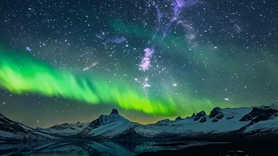 Vibrant Aurora Borealis Dancing Over Snowy Mountain Range