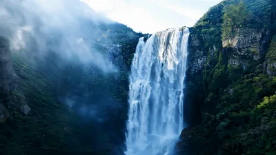 Majestic Waterfall Cascading Down Lush Green Mountain Cliffs
