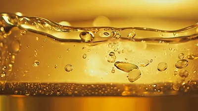 Golden Liquid Bubbles Rising In A Glass