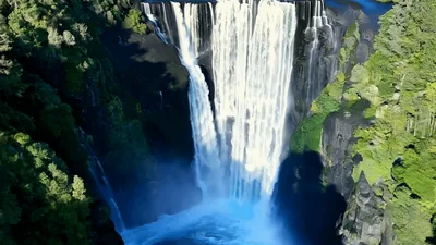 Aerial View Of Majestic Waterfall Cascading Into Deep Gorge